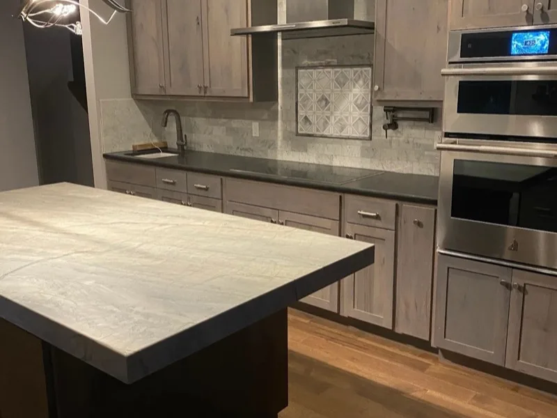 Kitchen remodel with gray-stained cabinets and double wall ovens