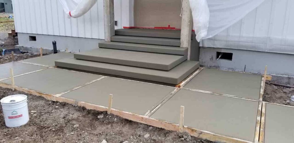 Poured concrete patio and steps in front of a door
